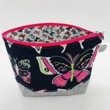 Load image into Gallery viewer, The pouch is made from 100% quilting cotton with a large pink and white butterflies on blue print by Art Gallery Fabrics, Kaufman Essex cotton/linen for the base, and a layer of fleece. The cute metal tassel gives an added touch. 7.5 W x 6”H x 2.5”D. Machine washable and dryer safe, or air dry.