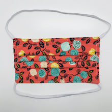 Load image into Gallery viewer, Masks are made of 2 layers of flowers on orange print 100% quilting cotton and have behind the head elastic bands. The masks also have a bendable aluminum nose. Wash in washing machine and dry in dryer after each use. 7” H x 7.5” W