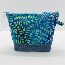Load image into Gallery viewer, The pouch is made from 100% batik quilting cotton with a blue, purple and green leaves print, Kaufman Essex cotton/linen for the base, and a layer of fleece. The cute metal tassel gives an added touch. 7.5 W x 6”H x 2.5”D. Machine washable and dryer safe, or air dry.