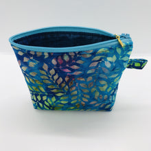 Load image into Gallery viewer, The pouch is made of 100% batik quilting cotton of blue, purple and green leaves and a layer of fleece for stability. The cute metal tassel gives an added touch. 6”W x 4.5” H x 1”D. Machine washable and dryer safe, or air dry.