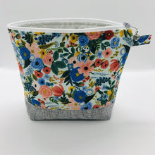 Load image into Gallery viewer, The pouch is made from 100% quilting cotton by Rifle Paper Co and features a multicolored woodland floral print, Kaufman Essex cotton/linen for the base, and a layer of fleece. The cute metal tassel gives an added touch. 7.5 W x 6”H x 2.5”D. Machine washable and dryer safe, or air dry.