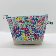 Load image into Gallery viewer, The pouch is made from 100% quilting cotton with a spring flower print, Kaufman Essex cotton/linen for the base, and a layer of fleece. The cute metal tassel gives an added touch. 7.5 W x 6”H x 2.5”D. Machine washable and dryer safe, or air dry.