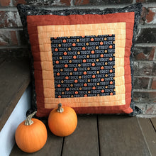 Load image into Gallery viewer, Trick or Treat pillow cover, 100% cotton with spiderwebs, pumpkins, “trick or treat” words, orange and black prints and solids. Quilted with a meandering design by machine with 40 wt Aurifil thread and has a hidden zipper in the solid black pillow back. The pillow cover only is offered and does not include the pillow form insert of 18” x 18” or 20” x 20”. Machine wash with like colors in cold water with low suds soap such as Woolite, line dry.