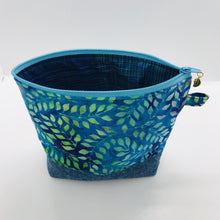 Load image into Gallery viewer, The pouch is made from 100% batik quilting cotton with a blue, purple and green leaves print, Kaufman Essex cotton/linen for the base, and a layer of fleece. The cute metal tassel gives an added touch. 7.5 W x 6”H x 2.5”D. Machine washable and dryer safe, or air dry.