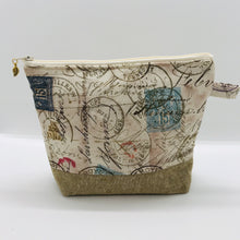 Load image into Gallery viewer, The pouch is made from 100% quilting cotton with tan antique stamp print, Kaufman Essex cotton/linen for the base, and a layer of fleece. The cute metal tassel gives an added touch. 7.5 W x 6”H x 2.5”D. Machine washable and dryer safe, or air dry.