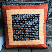 Load image into Gallery viewer, Trick or Treat pillow cover, 100% cotton with spiderwebs, pumpkins, “trick or treat” words, orange and black prints and solids. Quilted with a meandering design by machine with 40 wt Aurifil thread and has a hidden zipper in the solid black pillow back. The pillow cover only is offered and does not include the pillow form insert of 18” x 18” or 20” x 20”. Machine wash with like colors in cold water with low suds soap such as Woolite, line dry.