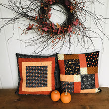 Load image into Gallery viewer, Scrappy Halloween pillow cover, 100% cotton in orange, black and gold prints. The pillow is quilted with a meandering design by machine with 40 wt Aurifil thread and has a hidden zipper in the back made of black Kona Cotton. The pillow cover only is offered and does not include the pillow form insert. The pillow insert needed is 18 x 18 inches. Machine wash with like colors in cold water with low suds soap such as Woolite, line dry.