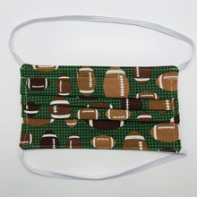 Load image into Gallery viewer, Made with three layers footballs on green print 100% quilting cotton, this mask includes a filter pocket located in the pleats in the back of the mask for a filter of your choice, elastic head bands and a bendable aluminum nose. Machine wash and dry after each use. 7” H x 7.5” W