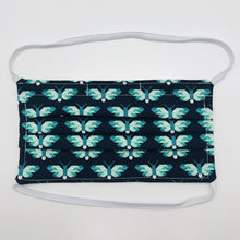 Load image into Gallery viewer, Masks are made of 2 layers of green and white butterflies on navy print 100% quilting cotton and have behind the head elastic bands. The masks also have a bendable aluminum nose. Wash in washing machine and dry in dryer after each use. 7” H x 7.5” W