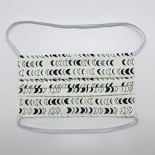 Load image into Gallery viewer, Masks are made of 2 layers 100% quilting cotton featuring blue, white and black half moons in rows on white background print, over the head elastic loops and a bendable aluminum nose. Wash in washing machine and dry in dryer after each use. 7” H x 7.5” W
