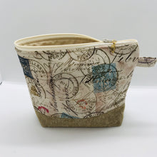 Load image into Gallery viewer, The pouch is made from 100% quilting cotton with tan antique stamp print, Kaufman Essex cotton/linen for the base, and a layer of fleece. The cute metal tassel gives an added touch. 7.5 W x 6”H x 2.5”D. Machine washable and dryer safe, or air dry.