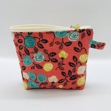 Load image into Gallery viewer, The pouch is made from 100% cotton flowers on orange print and has a layer of fleece for structure and a cute metal tassel. The pouch design is from the Becca Bags pattern from Lazy Girl Design. 6”W x 4.5” H x 1”D. Machine washable and dryer safe or air dry.