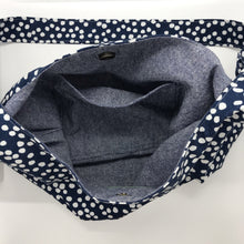 Load image into Gallery viewer, This beautiful 100% quilting cotton of a white dots on blue print makes a great tote bag that is light and durable. The lining is beautiful Essex cotton\linen from Robert Kaufman and has a magnetic snap and inner pocket. 15.5” W & 14”H. Total length with strap 33”