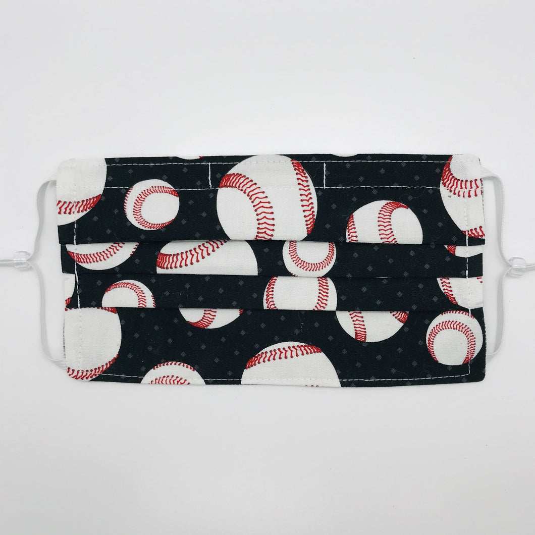 Made with three layers of baseballs on black print 100% quilting cotton, this mask includes a filter pocket located in the pleats in the back of the mask for a filter of your choice, adjustable elastic ear loops and a bendable aluminum nose. Machine wash and dry after each use. 7” H x 7.5” W