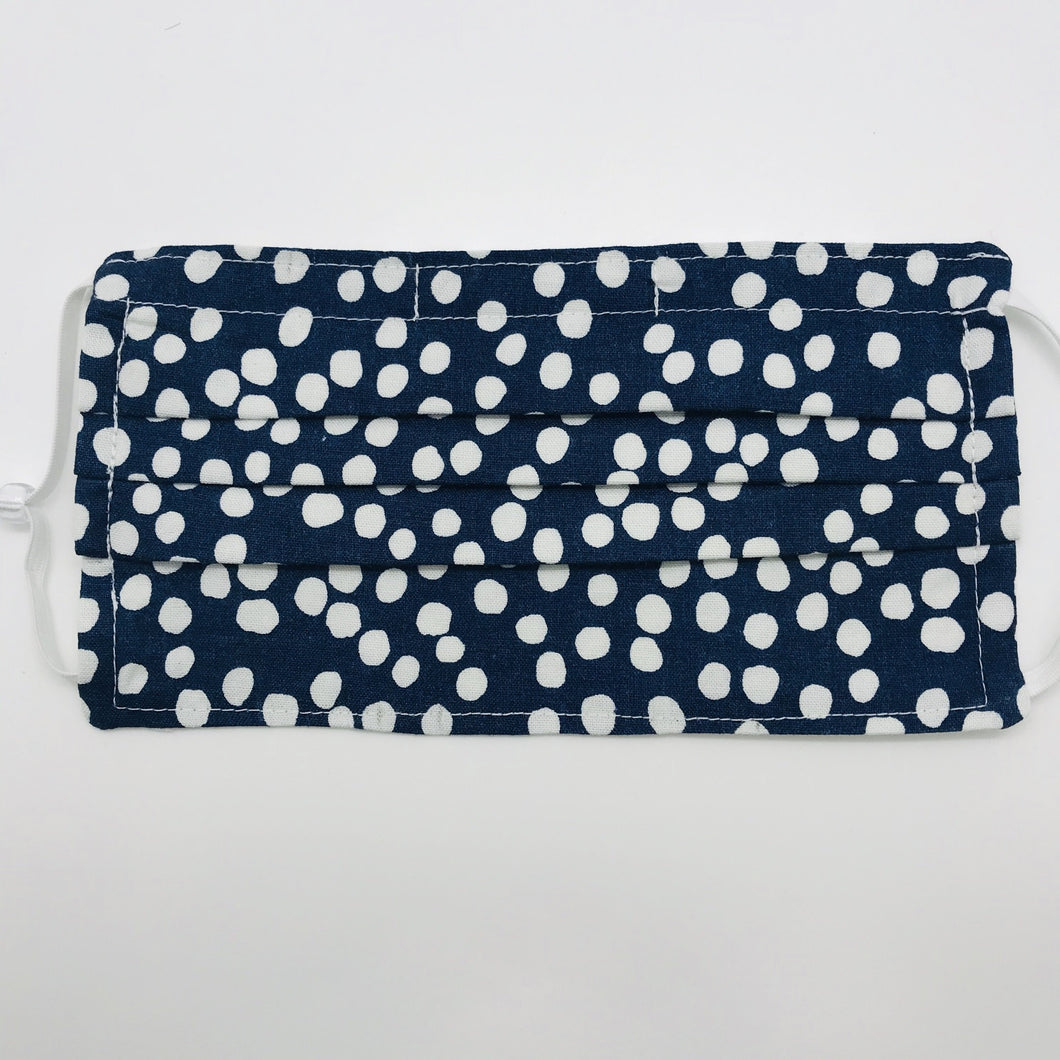 Made with three white dots on blue print 100% quilting cotton, this mask includes a filter pocket located in the pleats in the back of the mask for a filter of your choice, adjustable elastic ear loops and a bendable aluminum nose. Machine wash and dry after each use. 7” H x 7.5” W