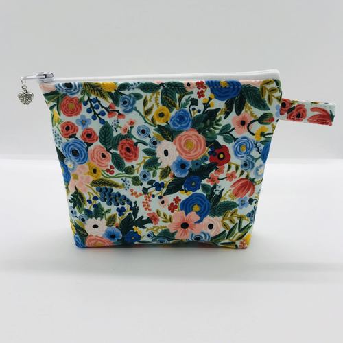 The pouch is made of 100% quilting cotton from Rifle Paper Co and features a multicolored woodland floral print and a layer of fleece for stability. The cute metal tassel gives an added touch. 6”W x 4.5” H x 1”D. Machine washable and dryer safe, or air dry.