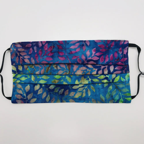 Masks have three layers of 100% cotton with blue, green and purple leaves batik and include a filter pocket located in the pleats in the back of the mask for a filter of your choice. Masks have adjustable elastic ear loops and an aluminum nose piece. Machine wash and dry after each use. 7” H x 7.5” W
