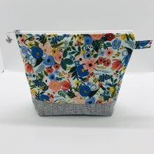 Load image into Gallery viewer, The pouch is made from 100% quilting cotton by Rifle Paper Co and features a multicolored woodland floral print, Kaufman Essex cotton/linen for the base, and a layer of fleece. The cute metal tassel gives an added touch. 7.5 W x 6”H x 2.5”D. Machine washable and dryer safe, or air dry.
