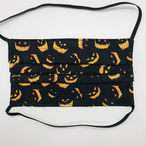 Masks are made of 2 layers 100% quilting cotton featuring a print of spooky orange faces on black, over the head elastic loops and a bendable aluminum nose. Wash in washing machine and dry in dryer after each use. 7” H x 7.5” W 