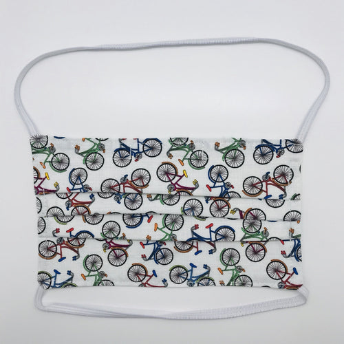 Masks are made of 100% quilting-weight cotton featuring multi colored bikes on a white background.  This mask has elastic bands and a bendable nose piece. Wash in washing machine and dry in dryer after each use. 7” H x 7.5” W
