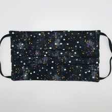 Load image into Gallery viewer, Made with three layers of small white, gold and purple dots on black print 100% quilting cotton, this mask includes a filter pocket located in the pleats in the back of the mask for a filter of your choice, adjustable elastic ear loops and a bendable aluminum nose. Machine wash and dry after each use. 7” H x 7.5” W
