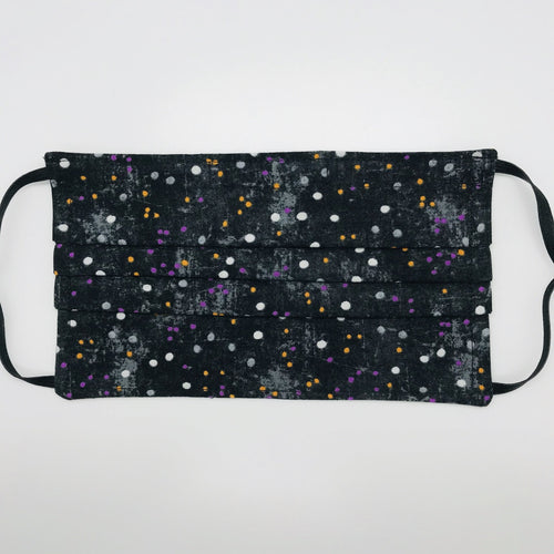 Made with three layers of small white, gold and purple dots on black print 100% quilting cotton, this mask includes a filter pocket located in the pleats in the back of the mask for a filter of your choice, adjustable elastic ear loops and a bendable aluminum nose. Machine wash and dry after each use. 7” H x 7.5” W