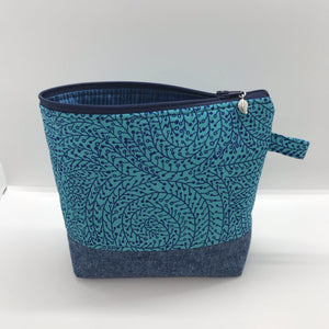 The pouch is made from 100% quilting cotton with a blue/teal vine maze print, Kaufman Essex cotton/linen for the base, and a layer of fleece. The cute metal tassel gives an added touch. 7.5 W x 6”H x 2.5”D. Machine washable and dryer safe, or air dry.
