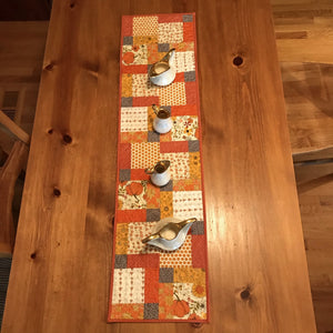 Beautiful fall colors table runner. 100% cotton, disappearing nine patch design. free-motion quilted in circular design. machine wash cold, line dry. 44" L x 11.5" W