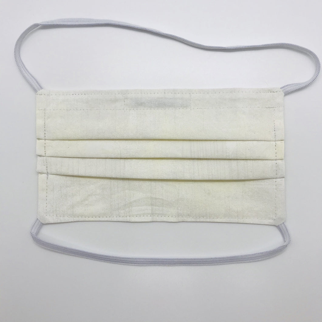Masks are made of 2 layers 100% quilting cotton featuring a white/cream textured grunge  print, over the head elastic loops and a bendable aluminum nose. Wash in washing machine and dry in dryer after each use. 7” H x 7.5” W 