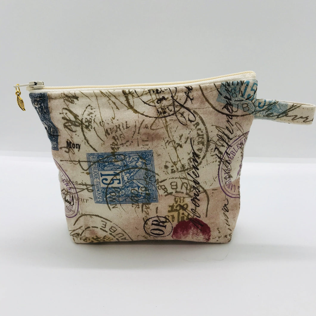 The small pouch is made from 100% tan antique stamp print and has a layer of fleece for structure and a cute metal tassel. The pouch design is from the Becca Bags pattern from Lazy Girl Design. 6”W x 4.5” H x 1”D. Machine washable and dryer safe or air dry.