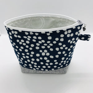 The pouch is made from 100% quilting cotton with a white dots on blue print, Kaufman Essex cotton/linen for the base, and a layer of fleece. The cute metal tassel gives an added touch. 7.5 W x 6”H x 2.5”D. Machine washable and dryer safe, or air dry.