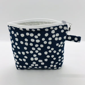 The pouch is made of 100% quilting cotton of a white dots on blue print and a layer of fleece for stability. The cute metal tassel gives an added touch. 6”W x 4.5” H x 1”D. Machine washable and dryer safe, or air dry.