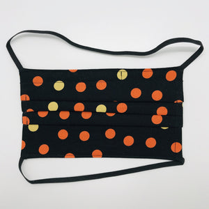 Masks are made of 2 layers 100% quilting cotton featuring a print of orange and gold dots on black, over the head elastic loops and a bendable aluminum nose. Wash in washing machine and dry in dryer after each use. 7” H x 7.5” W 