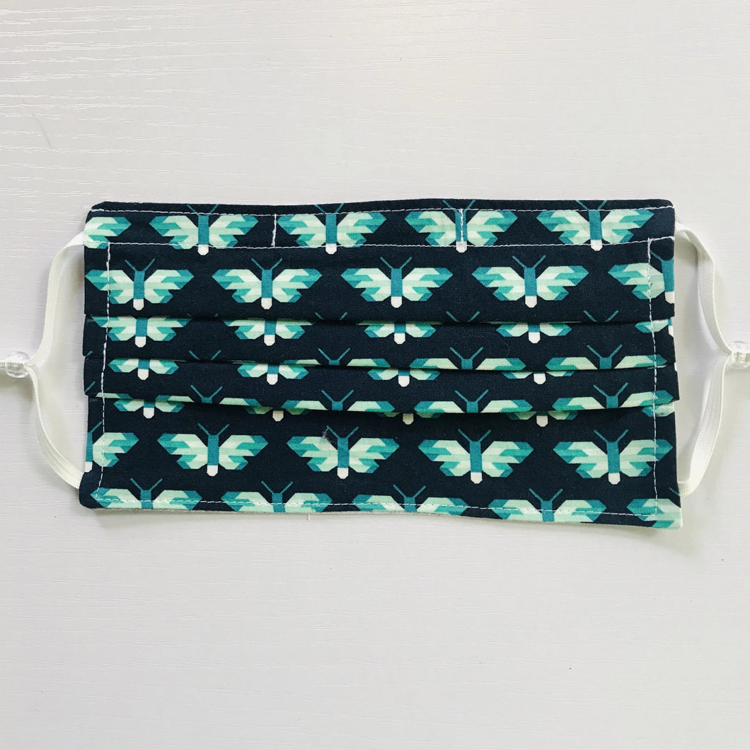 100% quilting-weight blue and green animal themed cotton face mask with adjustable elastic ear loops and bendable nose piece. Washable, reusable fabric face mask. Wash in washing machine and dry in dryer after each use. 7” H x 7.5” W  Butterflies in Ultra Marine - Pacific Collection - Elizabeth Hartman (designer)-Robert Kaufman Fabrics