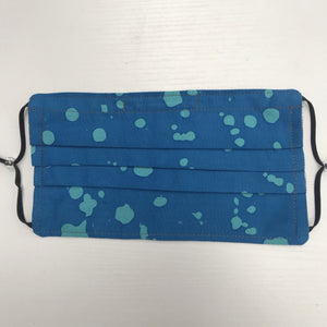100% quilting-weight batik cotton blue splatter design face mask with adjustable elastic ear loops and bendable nose piece. Washable, reusable fabric face mask. Wash in washing machine and dry in dryer after each use. 7” H x 7.5” W  Fabric from the Handcrafted Batiks collection by Alison Glass from Andover Fabrics. 