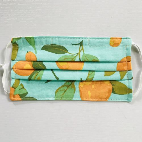 Made with three layers of peaches on blue/green print 100% quilting cotton, this mask includes a filter pocket located in the pleats in the back of the mask for a filter of your choice, adjustable elastic ear loops and a bendable aluminum nose. Machine wash and dry after each use. 7” H x 7.5” W