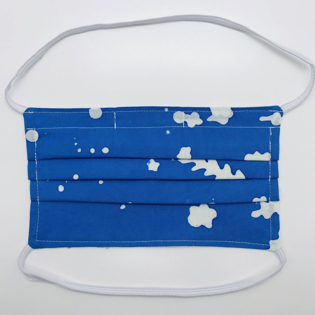 100% quilting-weight batik cotton blue and white face mask with behind the head elastic bands and bendable nose piece. Washable, reusable fabric face mask. Wash in washing machine and dry in dryer after each use. 7” H x 7.5” W Fabric from the Handcrafted Batiks collection by Alison Glass for Andover Fabrics.