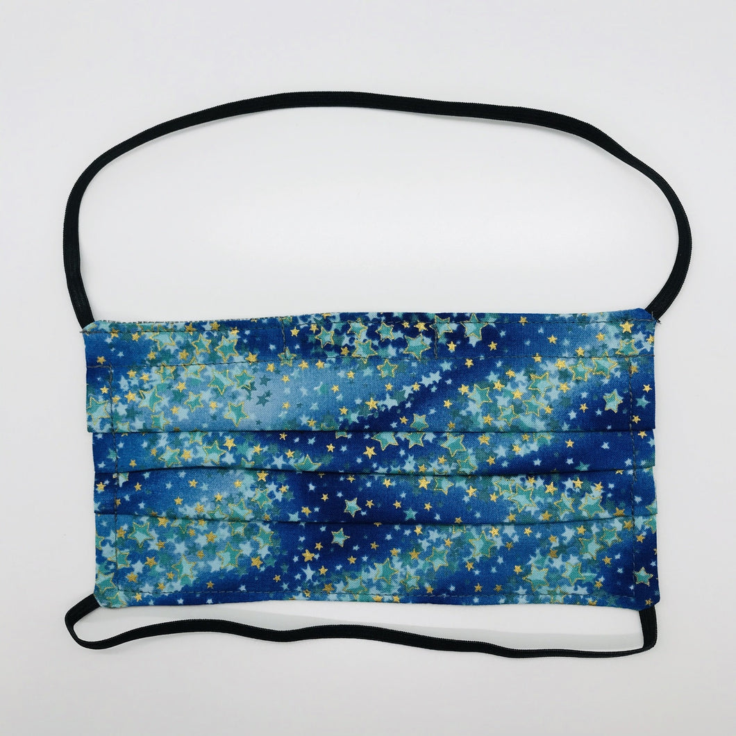 Masks are made of 2 layers 100% quilting cotton featuring blue/green with gold stars print, over the head elastic loops and a bendable aluminum nose. Wash in washing machine and dry in dryer after each use. 7” H x 7.5” W 