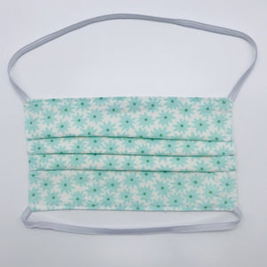 Masks are made of 2 layers of aqua flowers on white print 100% quilting cotton and have behind the head elastic bands. The masks also have a bendable aluminum nose. Wash in washing machine and dry in dryer after each use. 7” H x 7.5” W