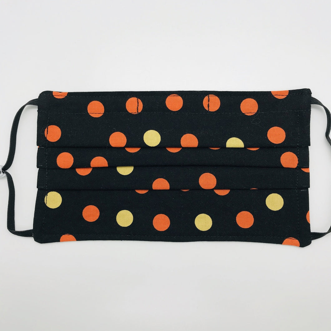 Masks are made of 2 layers 100% quilting cotton featuring a print of orange and gold dots on black, adjustable elastic ear loops and a bendable aluminum nose. Wash in washing machine and dry in dryer after each use. 7” H x 7.5” W