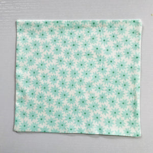 100% quilting-weight aqua green cotton face mask with twill tape straps and bendable nose piece. Washable, reusable fabric face mask. Wash in washing machine and dry in dryer after each use.  Fabric from the Pond collection by Elizabeth Hartman  7” H x 7.5” W