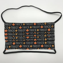 Load image into Gallery viewer, Masks are made of 2 layers 100% quilting cotton featuring a print of trick or treat words on black, over the head elastic loops and a bendable aluminum nose. Wash in washing machine and dry in dryer after each use. 7” H x 7.5” W 
