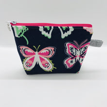 Load image into Gallery viewer,  The pouch is made of 100% quilting cotton from Art Gallery features a large pink and white butterflies on navy print and a layer of fleece for stability. The cute metal tassel gives an added touch. 6”W x 4.5” H x 1”D. Machine washable and dryer safe, or air dry.
