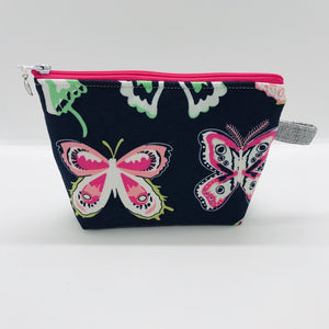  The pouch is made of 100% quilting cotton from Art Gallery features a large pink and white butterflies on navy print and a layer of fleece for stability. The cute metal tassel gives an added touch. 6”W x 4.5” H x 1”D. Machine washable and dryer safe, or air dry.