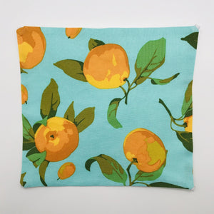 Image of peaches on a blue/green background printed cotton.