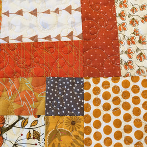 Beautiful fall colors table runner. 100% cotton, disappearing nine patch design. free-motion quilted in circular design. machine wash cold, line dry. 44" L x 11.5" W