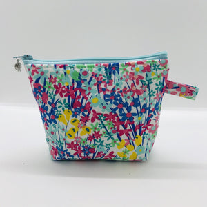 The small pouch is made from 100% cotton spring flowers print and has a layer of fleece for structure and a cute metal tassel. The pouch design is from the Becca Bags pattern from Lazy Girl Design. 6”W x 4.5” H x 1”D. Machine washable and dryer safe or air dry.