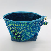 Load image into Gallery viewer, The pouch is made from 100% batik quilting cotton with a blue, purple and green leaves print, Kaufman Essex cotton/linen for the base, and a layer of fleece. The cute metal tassel gives an added touch. 7.5 W x 6”H x 2.5”D. Machine washable and dryer safe, or air dry.
