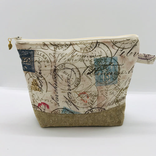 The pouch is made from 100% quilting cotton with tan antique stamp print, Kaufman Essex cotton/linen for the base, and a layer of fleece. The cute metal tassel gives an added touch. 7.5 W x 6”H x 2.5”D. Machine washable and dryer safe, or air dry.