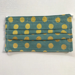100% quilting-weight green and gold dot cotton batik face mask with elastic bands and bendable nose piece. Washable, reusable fabric face mask. Wash in washing machine and dry in dryer after each use. 7” H x 7.5” W   